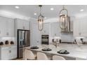 Modern kitchen with white cabinets, quartz countertops, and stainless steel appliances at 289 Vistera Blvd, Nokomis, FL 34275
