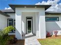 Modern front entry with gray trim and glass door at 23466 Garrett Ave, Port Charlotte, FL 33954