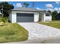 Modern one-story home with gray garage door and gray trim at 23466 Garrett Ave, Port Charlotte, FL 33954