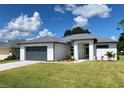 Modern one-story home with gray garage door and gray trim at 23466 Garrett Ave, Port Charlotte, FL 33954