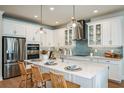 Modern kitchen featuring white cabinets, stainless steel appliances, and stylish lighting at 2036 Bolsena St, Nokomis, FL 34275
