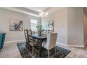 Dining room features hardwood floors, modern lighting fixture, neutral paint, and large area rug at 17126 Savory Mist Cir, Bradenton, FL 34211