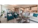 An open-concept living room and kitchen area featuring hardwood floors, modern lighting, and stainless steel appliances at 17126 Savory Mist Cir, Bradenton, FL 34211
