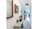 Bright hallway featuring neutral walls, a decorative mirror, and a clear view into the living spaces at 18149 Dillon Ave, Port Charlotte, FL 33954