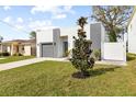 Modern home with a gray brick facade, tidy lawn and walkway and magnolia tree at 3508 E 11Th Ave, Tampa, FL 33605