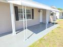Inviting front porch with decorative support posts, and window awnings offering curb appeal at 4823 Blossom Dr, Holiday, FL 34690