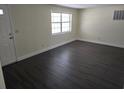 Spacious living room with wood-look floors, and plenty of natural light from the window at 4823 Blossom Dr, Holiday, FL 34690