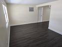 Bright living room with dark wood-look floors, neutral walls, and ample natural light at 4823 Blossom Dr, Holiday, FL 34690