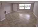 Bright living room with tiled floors, a large window, and freshly painted walls at 7352 Sequoia Dr, New Port Richey, FL 34653