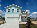 Two-story home with a two car garage and blue accents at 7959 Chandler Lake Ct, Hudson, FL 34667