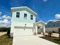 Charming two-story home with a light blue exterior and a two-car garage, complemented by new landscaping at 7959 Chandler Lake Ct, Hudson, FL 34667