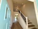 Elegant foyer featuring a staircase with wrought iron railing, wood floors, and high ceilings at 7959 Chandler Lake Ct, Hudson, FL 34667