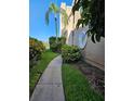 A beautiful condo exterior showcases unique round windows, complemented by lush landscaping and a sidewalk at 8744 54Th W Ave # 8744, Bradenton, FL 34210