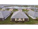 An aerial view of new homes with gray roofs, manicured lawns and a peaceful lake nearby at 18032 Cherished Loop, Bradenton, FL 34211