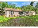 Exterior view of the home with a lush, green lawn and detached two car garage at 3703 Cooper Rd, Plant City, FL 33565