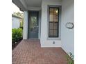 Inviting front entrance with a decorative door, sidelight window, and brick-paved porch at 2735 Lavandula Ct, North Port, FL 34289