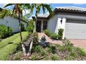 Charming home featuring lush landscaping, decorative plants, and a brick pathway leading to the entrance at 2735 Lavandula Ct, North Port, FL 34289