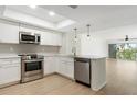 Stylish kitchen features stainless steel appliances, white cabinetry, and an open floor plan at 9874 Indian Key Trl # 62, Seminole, FL 33776