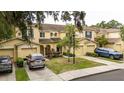 Three yellow townhomes, each with attached garages and manicured lawns at 10821 Great Carlisle Ct, Riverview, FL 33578