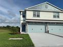A two-story townhome with an attached two-car garage and green lawn at 13978 Emerald Fields Dr, Hudson, FL 34667