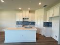 Bright kitchen with white cabinets, an island, and modern finishes at 13978 Emerald Fields Dr, Hudson, FL 34667