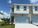 Beautiful townhome with stone accents, light blue trim, and a one-car garage at 14012 Emerald Fields Dr, Hudson, FL 34667