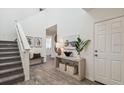 Welcoming entryway with hardwood floors, console table and staircase leading to the upper level at 16836 Fiesta Dr, Port Charlotte, FL 33953