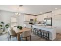 Eat-in kitchen with a center island, modern stainless steel appliances and white cabinets at 16836 Fiesta Dr, Port Charlotte, FL 33953