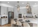Bright kitchen features white cabinets, granite countertops, stainless steel appliances and a large kitchen island at 1688 Lugano Cir, Nokomis, FL 34275