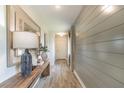 Bright hallway with stylish wood-look flooring, shiplap accent wall, and a decorative console table at 2046 Sunset Preserve Way, Port Charlotte, FL 33953