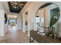Inviting foyer with decorative light fixture, mirror, and view of the living room at 236 Vistera Blvd, Nokomis, FL 34275