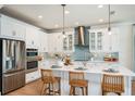 Modern kitchen features white cabinetry, stainless steel appliances, a central island, and stylish pendant lighting at 237 Vistera Blvd, North Venice, FL 34275