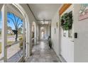 Enclosed front porch featuring tiled floors, white arched openings, and a ceiling fan at 567 Whippoorwill Dr, Venice, FL 34293