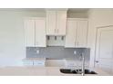 Kitchen with white cabinets, stainless steel appliances, subway tile backsplash, and quartz countertops at 13964 Emerald Fields Dr, Hudson, FL 34667