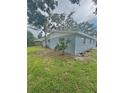 A view of the side yard and the side of the home with some green space at 4934 Avery Rd, New Port Richey, FL 34652