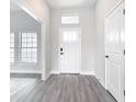 Bright foyer with white walls, wood-look flooring, and a transom window above the front door at 13527 Ainsworth Ln, Port Charlotte, FL 33981