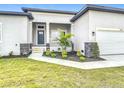 An inviting front porch with stone accents and white railings welcomes you to this beautiful home at 13527 Ainsworth Ln, Port Charlotte, FL 33981