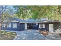 Ranch-style home with dark exterior paint and a large yard at 406 E Young St, Plant City, FL 33563