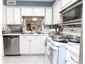 Bright kitchen featuring white cabinetry, stainless steel appliances, and ample counter space at 4222 Trucious Pl # 4222, New Port Richey, FL 34652