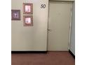 Hallway featuring neutral walls with a door labeled '50' and framed art at 2070 World Parkway Blvd # 50, Clearwater, FL 33763