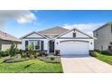 Beautiful single-story home with lush landscaping, a well-manicured lawn and a two-car garage at 17518 Canopy Pl, Bradenton, FL 34211