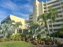 Modern building exterior with lush landscaping and palm trees at 6009 Sea Ranch Dr # 214, Hudson, FL 34667