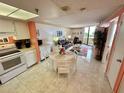 Open concept kitchen and dining area with white appliances and a round table at 6009 Sea Ranch Dr # 214, Hudson, FL 34667