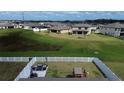 Aerial view of a spacious backyard with a white fence, patio furniture, and a playground, perfect for outdoor enjoyment at 12764 Weston Oaks Ln, Riverview, FL 33579