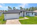 Charming single-story home with a brick driveway and lush green lawn at 8489 Topeka Cir, Port Charlotte, FL 33981