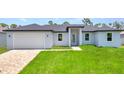 Charming single-story home with a brick driveway and lush green lawn at 8489 Topeka Cir, Port Charlotte, FL 33981