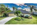 House with circular driveway and tropical landscaping at 39 Tee View Pl, Rotonda West, FL 33947