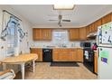 Cozy kitchen features wood cabinets, black appliances, and a small dining area at 5846 Greenbriar Ct, Zephyrhills, FL 33542