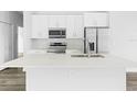 Modern kitchen featuring white cabinets, stainless steel appliances, and a large island at 22112 Mamaroneck Ave, Port Charlotte, FL 33952