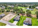 Aerial view of homes showcasing their landscaped lawns, proximity to a golf course, and neighborhood at 9049 Players Dr, Weeki Wachee, FL 34613